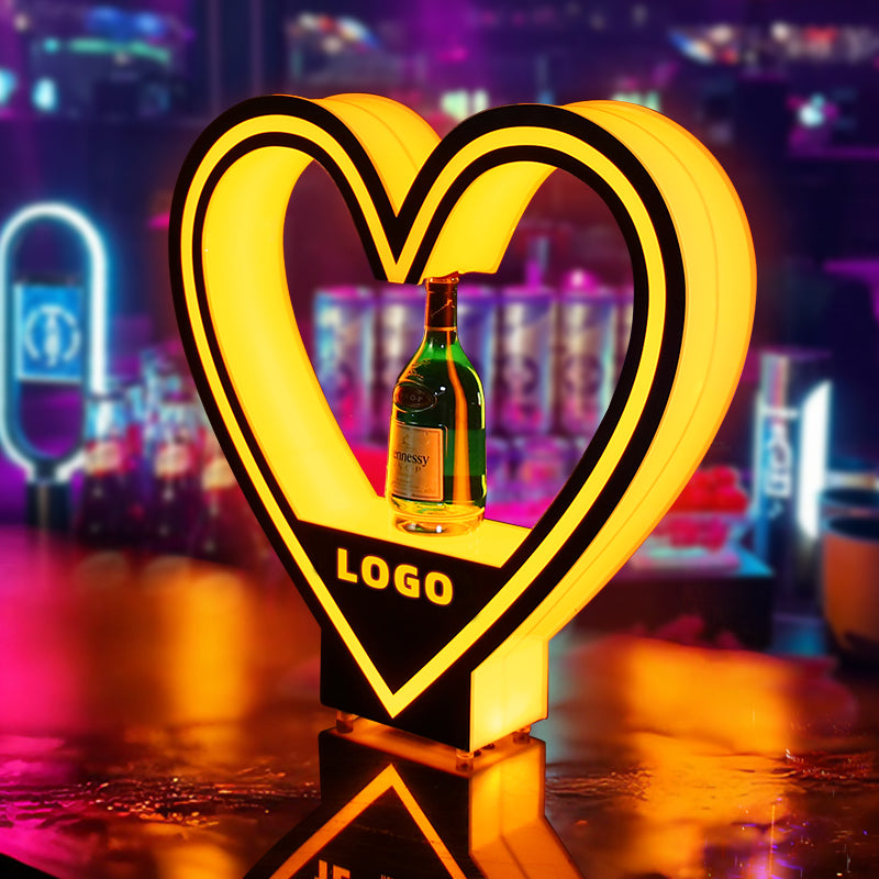 Custom heart-shaped LED bottle presenter with yellow glow lighting and bespoke brand logo for VIP nightclub service.